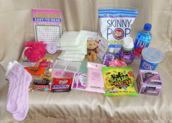 Premium monthly period box products displayed with feminine hygiene pads and indulgent healthy snacks.