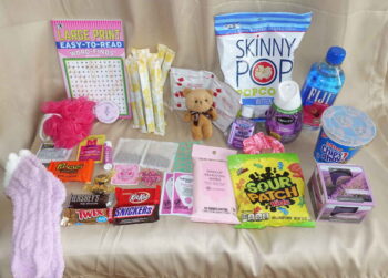 Premium monthly period box products displayed with feminine hygiene tampons and indulgent healthy snacks.